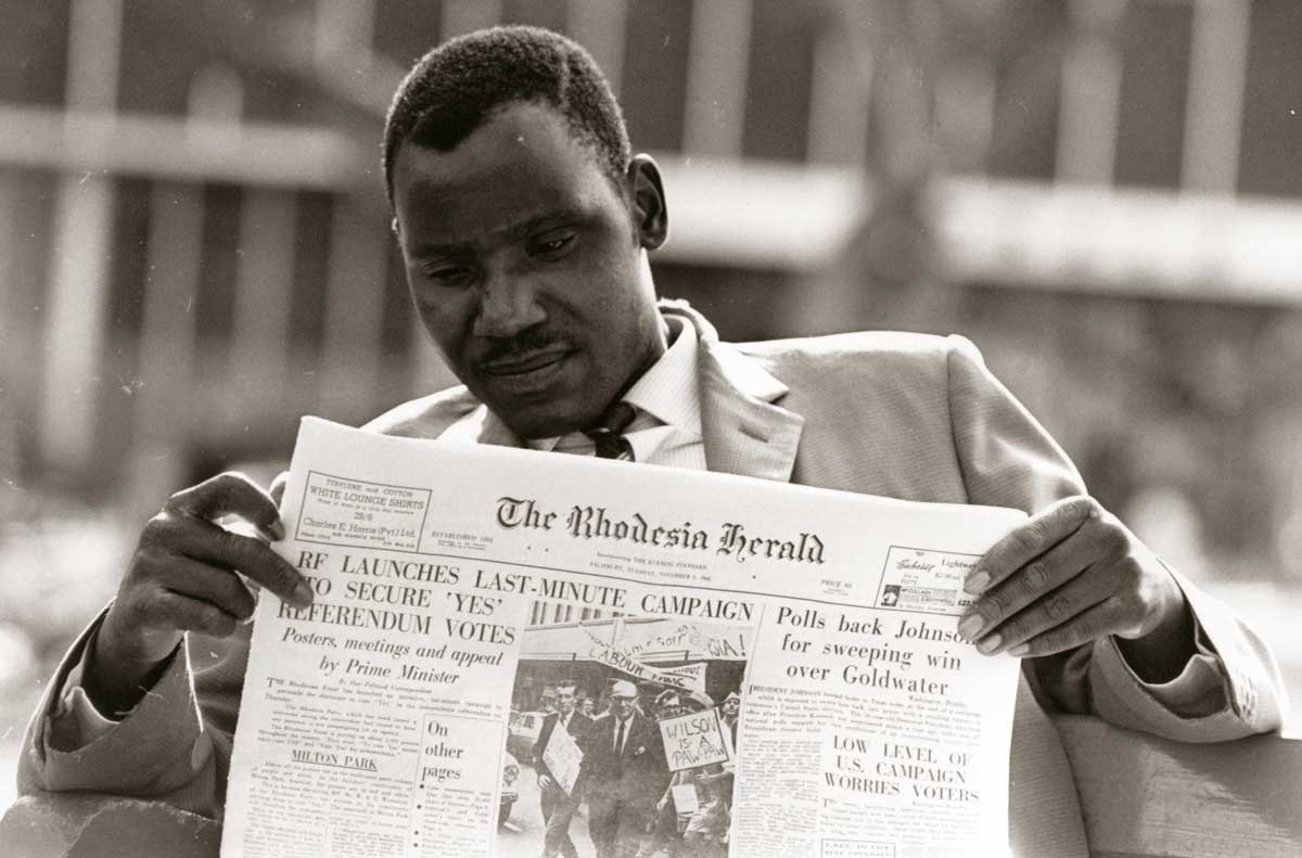 Man reading the Rhodesia Herald, November 1964 © Getty Images.