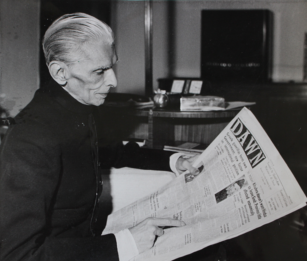 Jinnah reads a copy of the Pakistani newspaper Dawn, published to mark his 71st birthday, 25 December 1947.