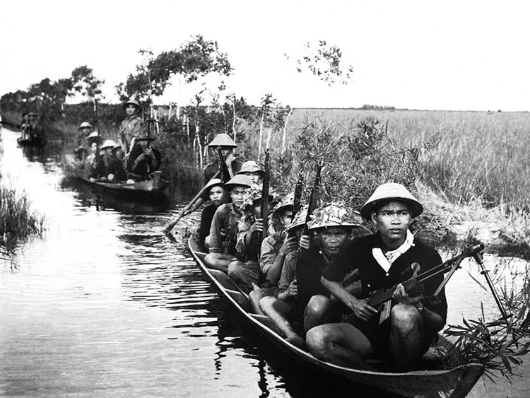 Guerrilla forces from North Vietnam's Viet Cong move across a river in 1966.