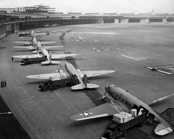 U.S. Navy Douglas R4D and U.S. Air Force C-47 aircraft unload at Tempelhof Airport during the Berlin Airlift, 1948-49