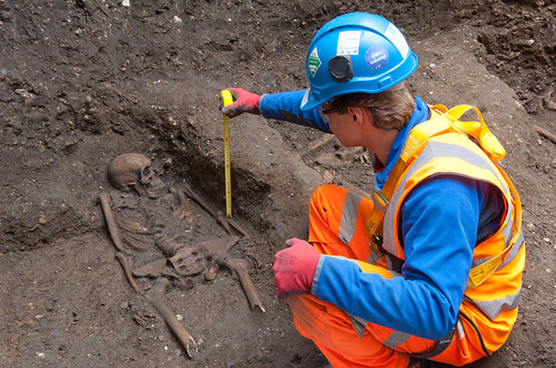 An archaeologist measures one of the skeletons. Photograph courtesy of Crossrail