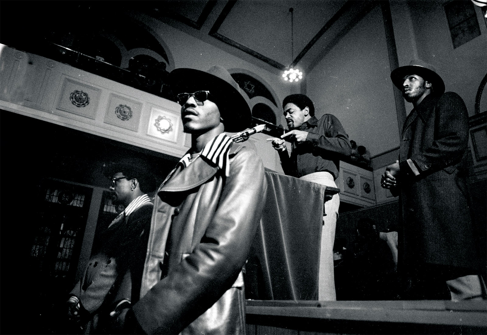 Black Panther Party leader Bobby Seale addresses a crowd from the podium flanked by bodyguards, Chicago, 1971.