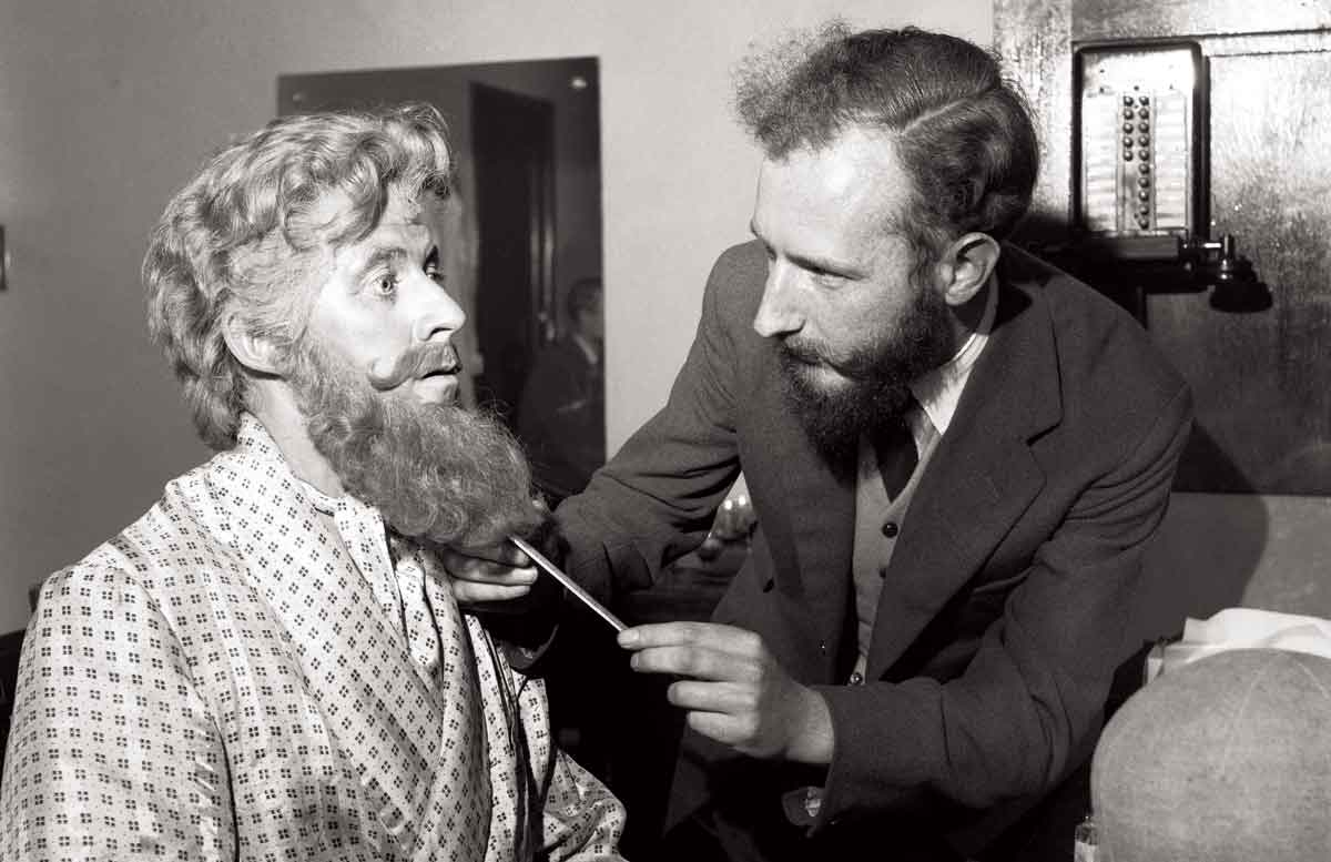 Bernard Braden (left) wearing a large false beard (red) at the Cambridge Theatre,  4 October 1954 © Getty Images