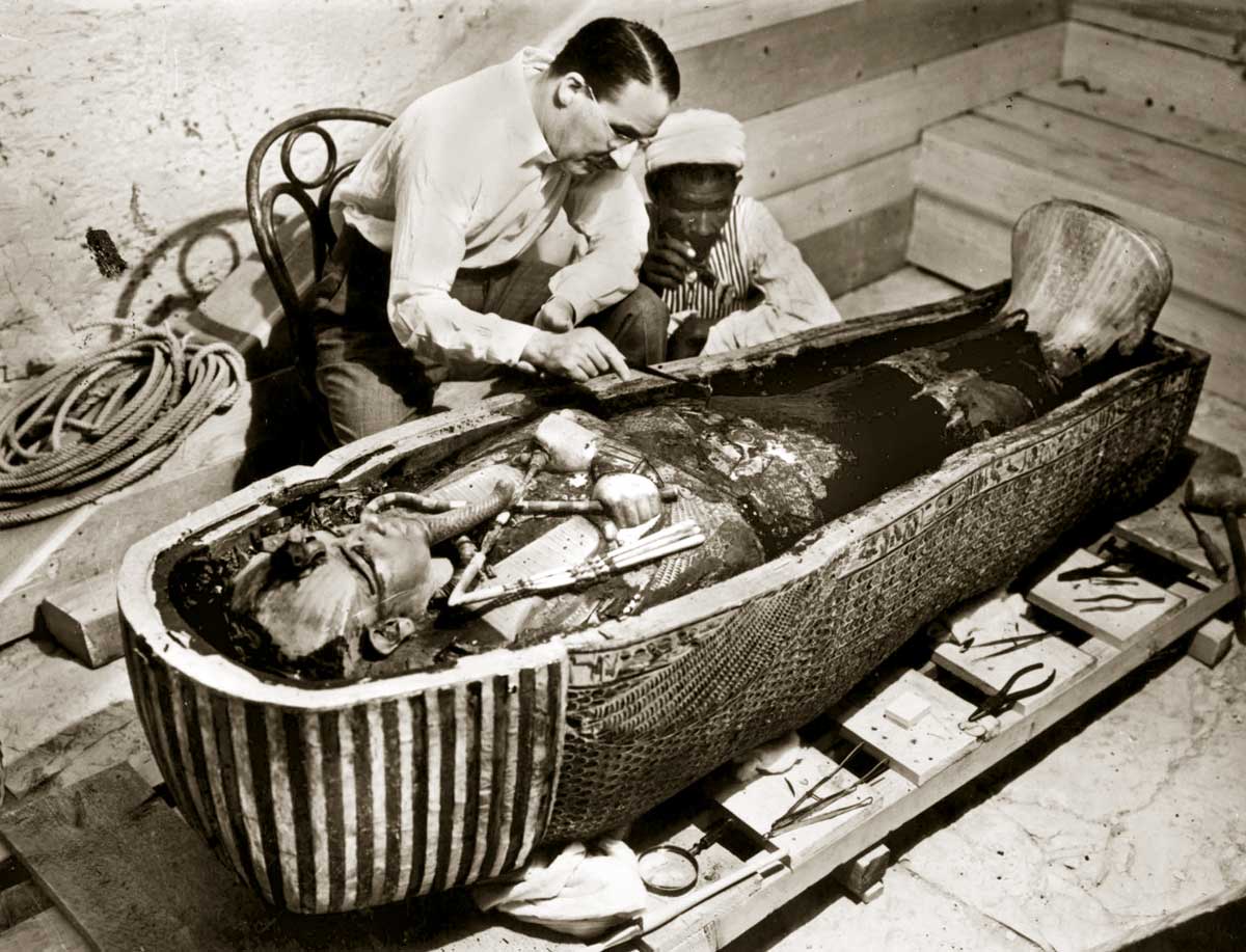 Howard Carter inspects the golden sarcophagus of Tutankhamun, Egypt, 1922.