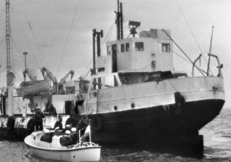 A Dutch navy boat pulls up alongside the Radio Caroline transmitter ship Mi Amigo, c. 1973. National Archives (CC0).