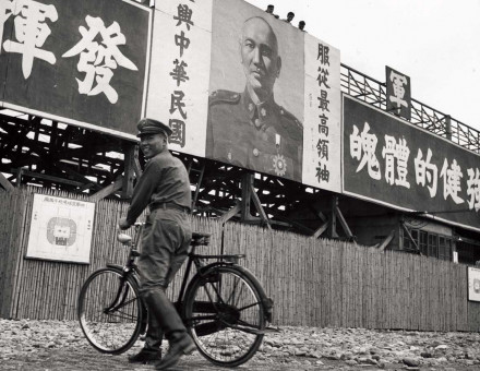 A soldier beneath a photo of Chiang Kai-shek inside the army gymnasium, Taipei, 1950s.