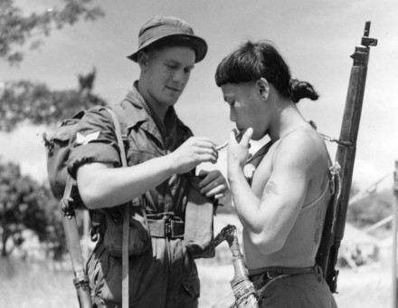 Brothers in arms?: a British soldier lights a cigarette for a Dyak colleague, Malaya, 1950. 