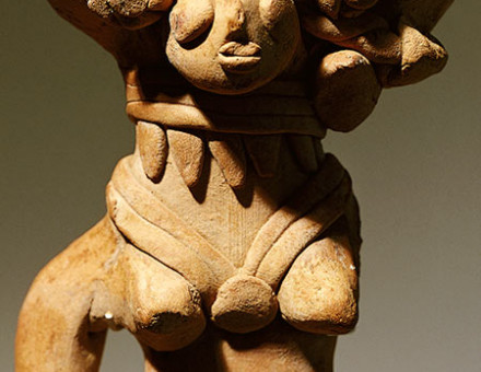 Terracotta figure with a headdress of flowers, rings and a belt, c.3000 BC.
