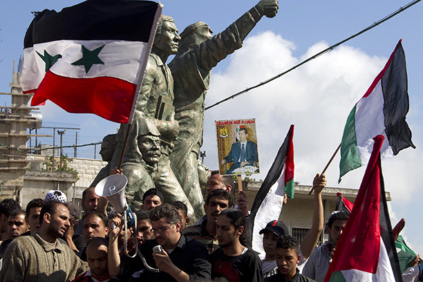 Flying the flag: Palestinians and Syrians hold a picture of President Bashar al-Assad as they mark the creation of the state of Israel, May 2011. Getty Images/AFP