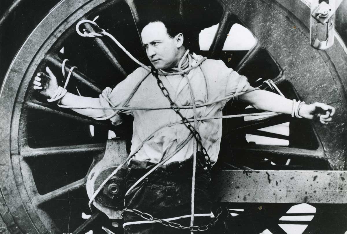 Harry Houdini strapped to a locomotive wheel, c.1910 © Getty Images.