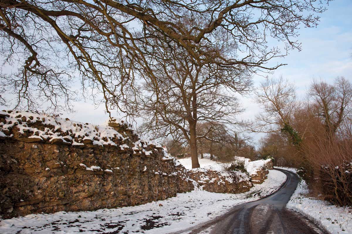 A road runs past the remains of the Roman wall at Silchester. Alamy.