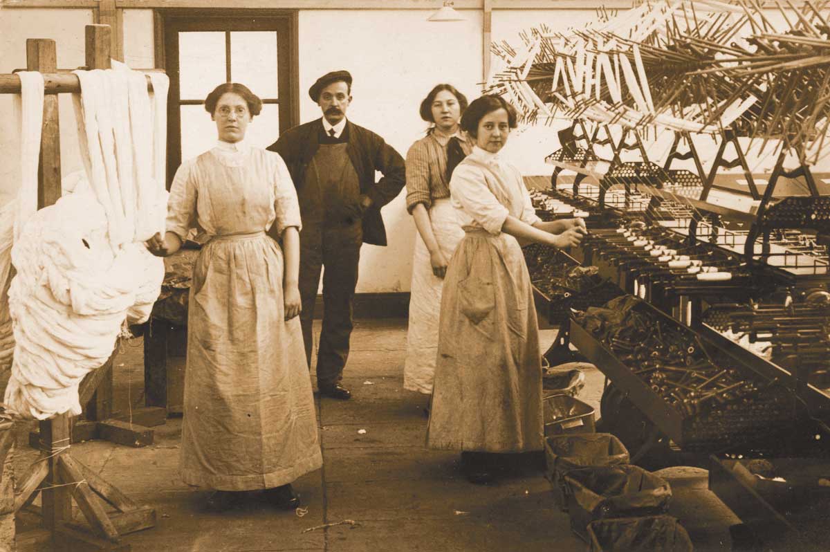 Bobbin winders and an overseer, Radcliffe, Lancashire, c.1915. Alamy.