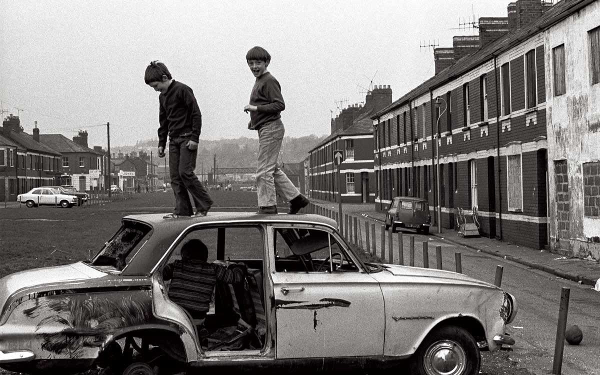 Boys playing on an abandoned car, Newport, 1974. Robin Weaver/Alamy.