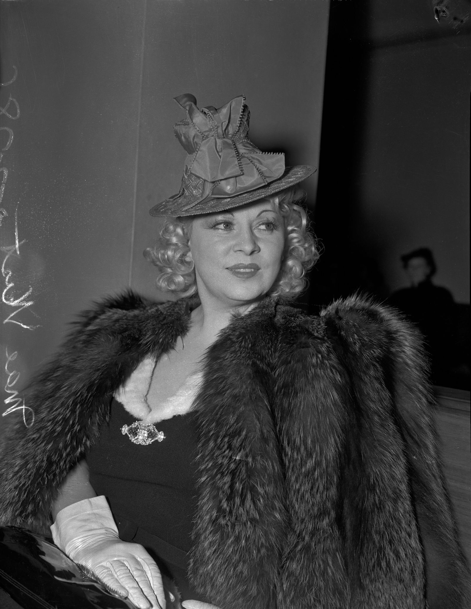 Mae West in court during questioning about earnings from her role in the movie She Done Him Wrong, Los Angeles, 1940. University of California, Los Angeles. Library. Department of Special Collections (CC BY 4.0 DEED).