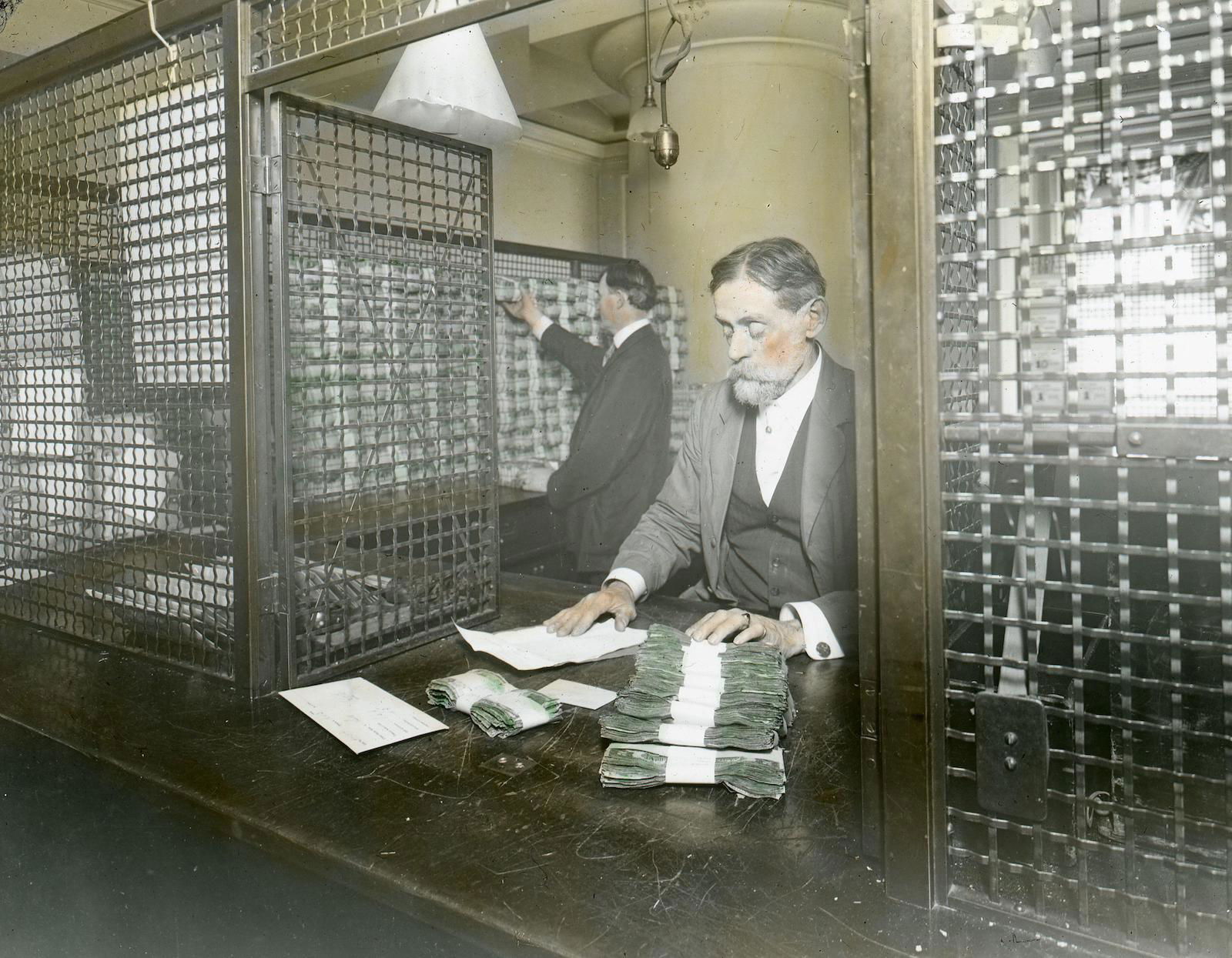 The receiving cashier’s cage at the US Treasury, to which money is returned  after verification, late 19th-early 20th century. piemags/N23/Alamy Stock Photo.