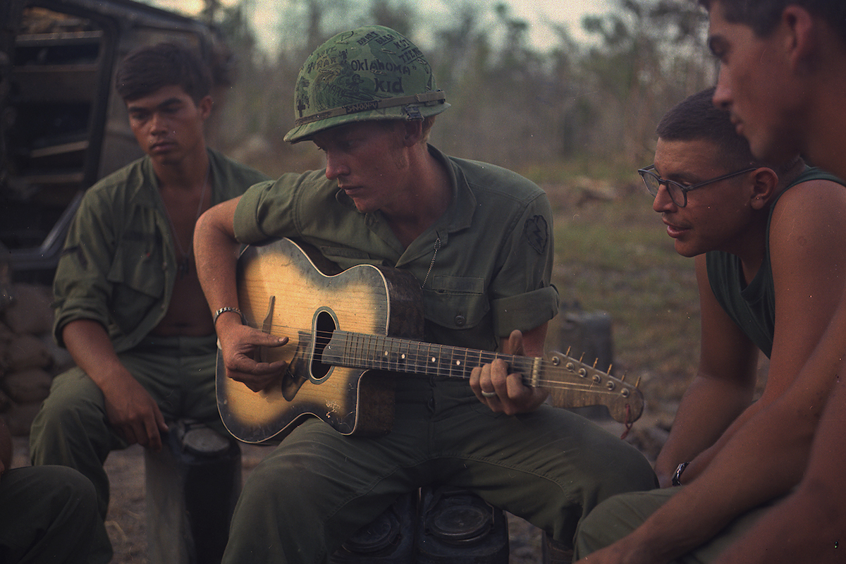 US soldiers gather around a guitar player during Operation Yellowstone, 18 January 1968. NARA. Public Domain.