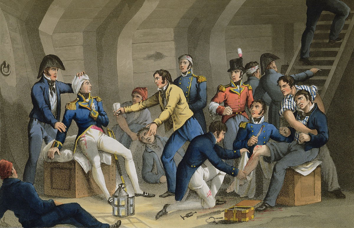 Nelson and other wounded officers being treated during the Battle of the Nile. Illustration by William Heath, from Historic, Military and Naval Anecdotes, 1819. Bridgeman Images.