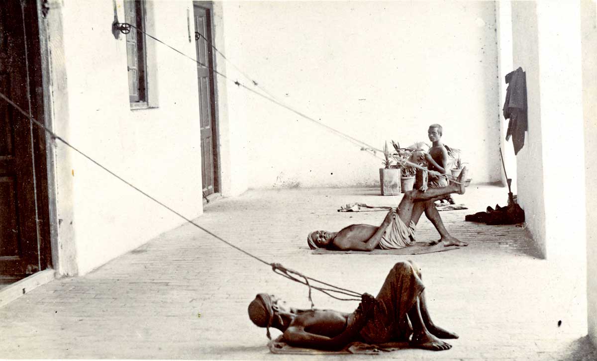 Three Indian men on a verandah pulling punkha strings, c.1900 © Royal Society for Asian Affairs, London/Bridgeman Images