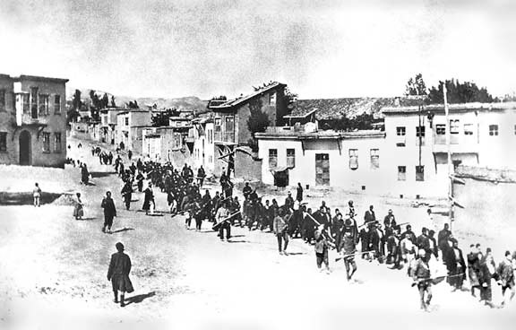 Armenian civilians, escorted by armed Ottoman soldiers, are marched through Harput (Kharpert), April 1915.