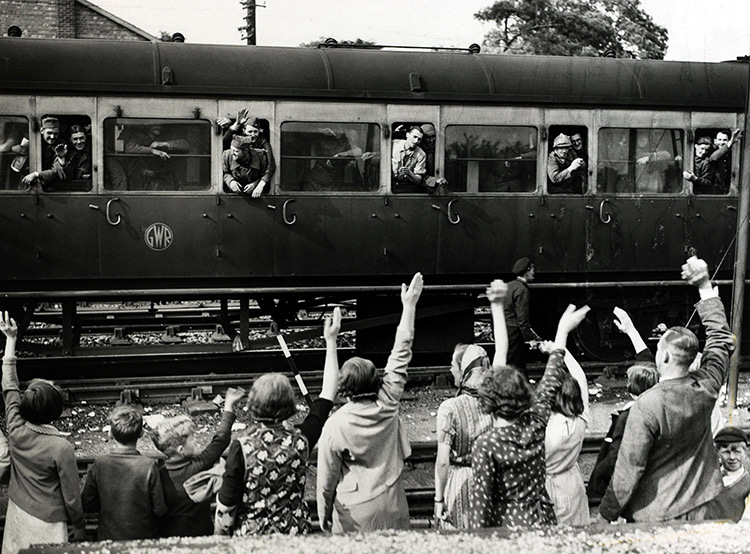 French Troops in a Great Western carriage and English women and children wave to each other at a station in Kent on May 31st, 1940.