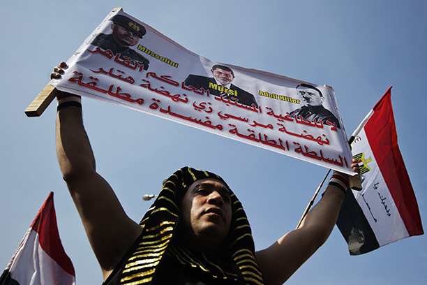 Past parallels: an anti-Morsi protester dressed as a pharoah, compares the Muslim Brotherhood leader to Mussolini and Hitler. Tahrir Square, Cairo, November 2012