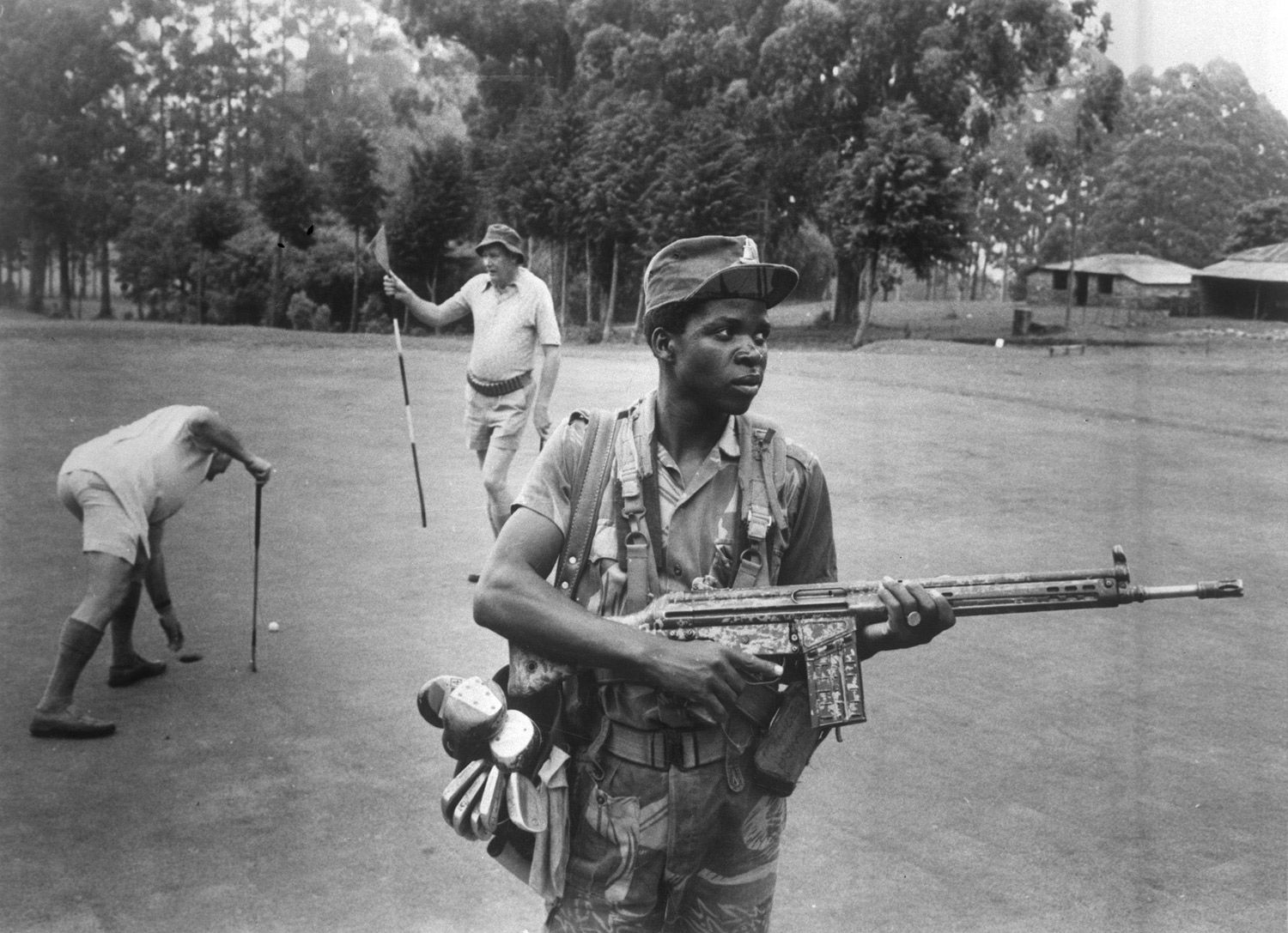 An armed guard provides security for white Rhodesian golfers at the Leopard Rock Hotel, Manicaland, 1978. Eddie Adams / Press Association Images