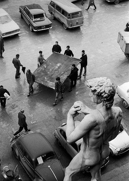 A monumental task: volunteers carry a painting to safety past the replica David in the Piazza della Signoria, 1966. Unstuck from the mud: volunteers rescue artworks in the Piazza della Signoria, Florence, 1966. © Getty Images.