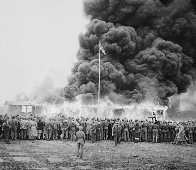 A crowd watches the destruction of the last camp hut.