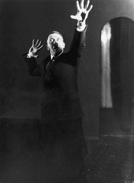 Hitler miming gestures to a record of his speeches; one of an extraordinary series of photographs he commissioned in 1925 to aid self-analysis and improve his hold over an audience.