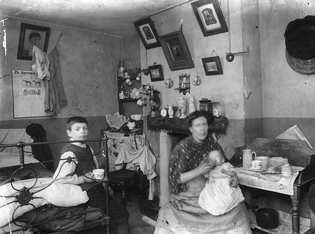 A mother with her baby and child in a typical London slum, December 1912. The bedroom also serves as a kitchen. Getty Images/Hulton Archive