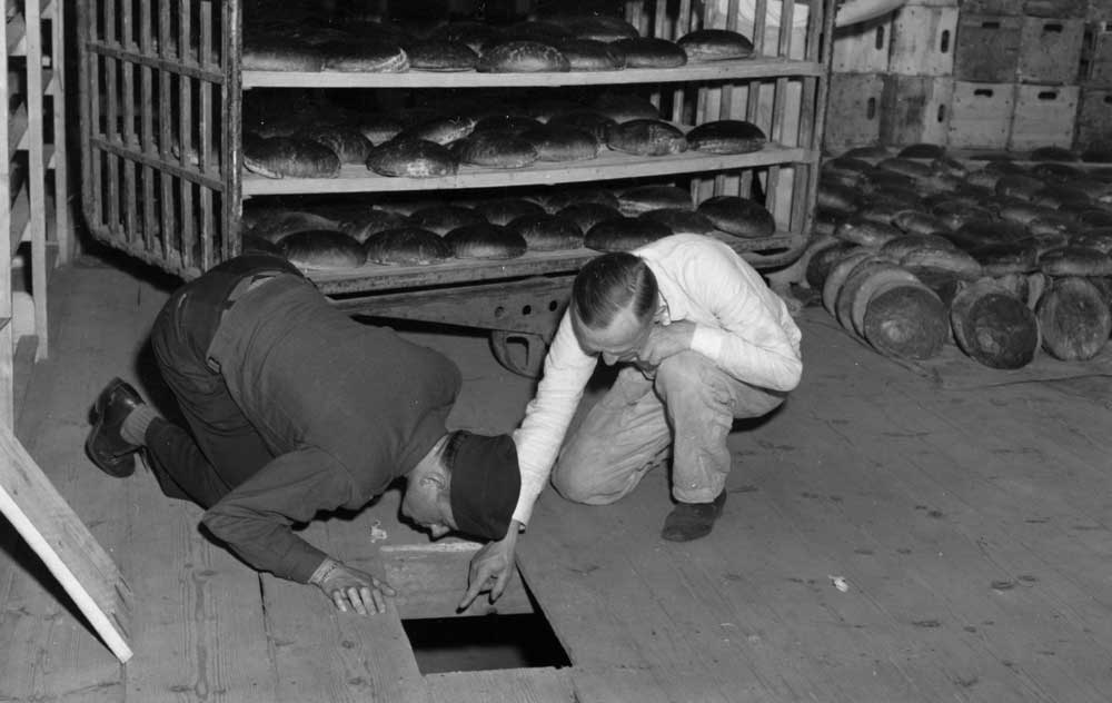 Lieutenant Robert R Rogers and Erich Pinkau from the German criminal police inspect the Konsum-Genossenschaftsbäckerei bakery in Nuremberg, 1946. Wiki Commons.