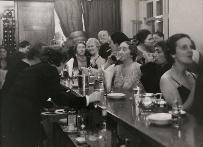 At the bar at the Covent Garden Opera in London, Erich Salomon, 1936. Berlin Gallery, Museum of Modern Art. Public Domain.