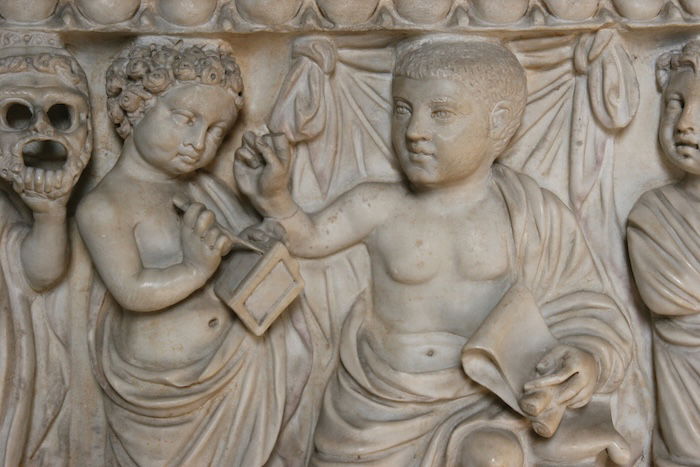 A relief from a sarcophagus showing a child writing on wax tablet, c.AD 280. 