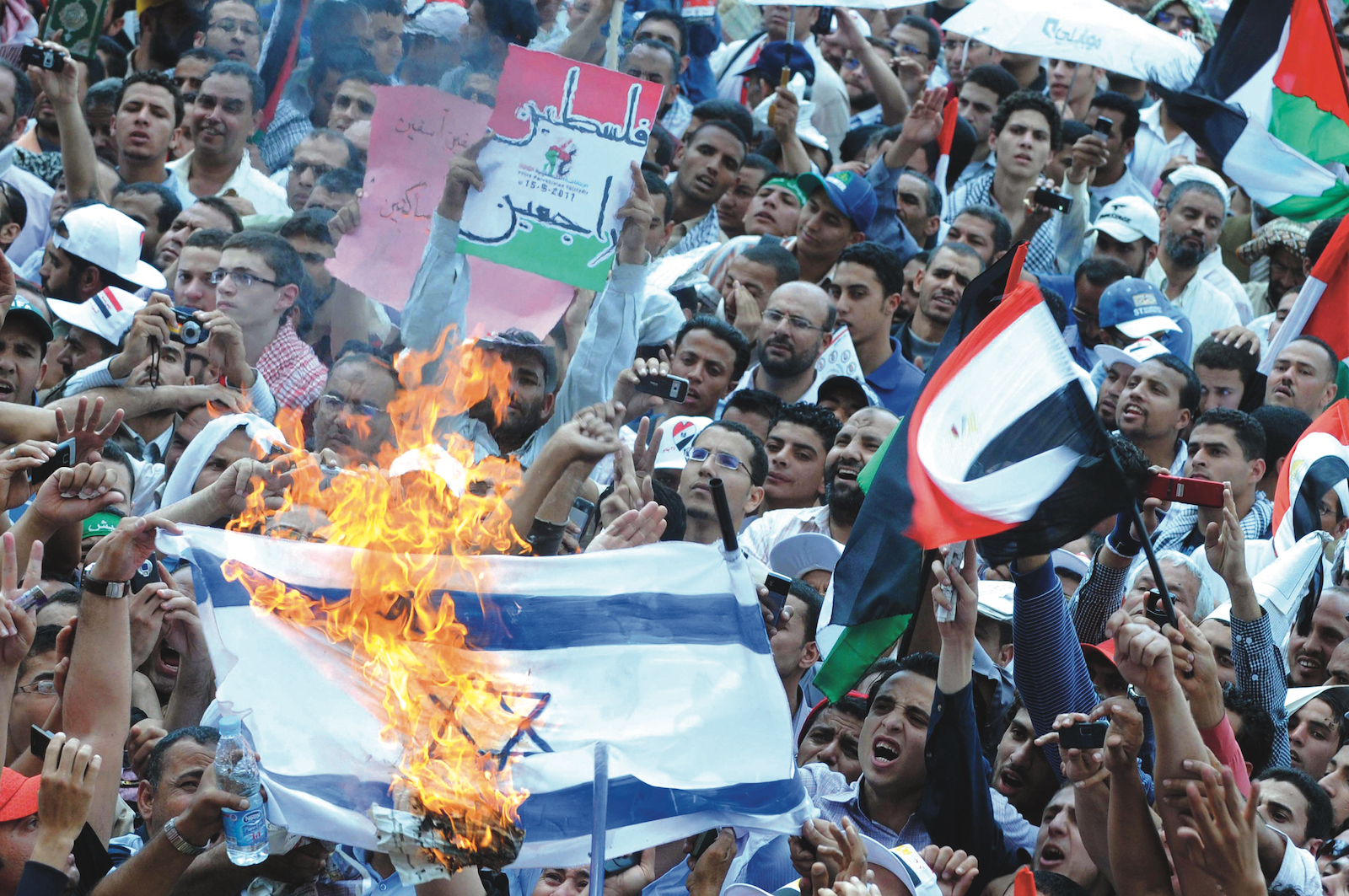 Egyptians burn an Israeli Palestine, Tahrir Square, flag during a protest Cairo, 13 May 2011. calling for unity and expressing solidarity with