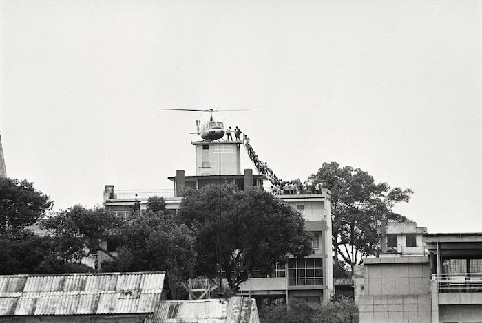 A CIA employee helps Vietnamese evacuees onto an Air America helicopter from the top of 22 Gia Long Street, half a mile from the US embassy.