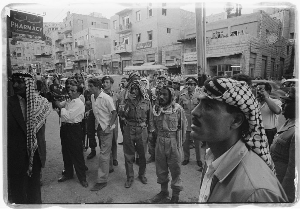 Men gathered on a street in Amman, Jordan, watching news of the 14 July Revolution, 1958. Library of Congress. Public Domain.