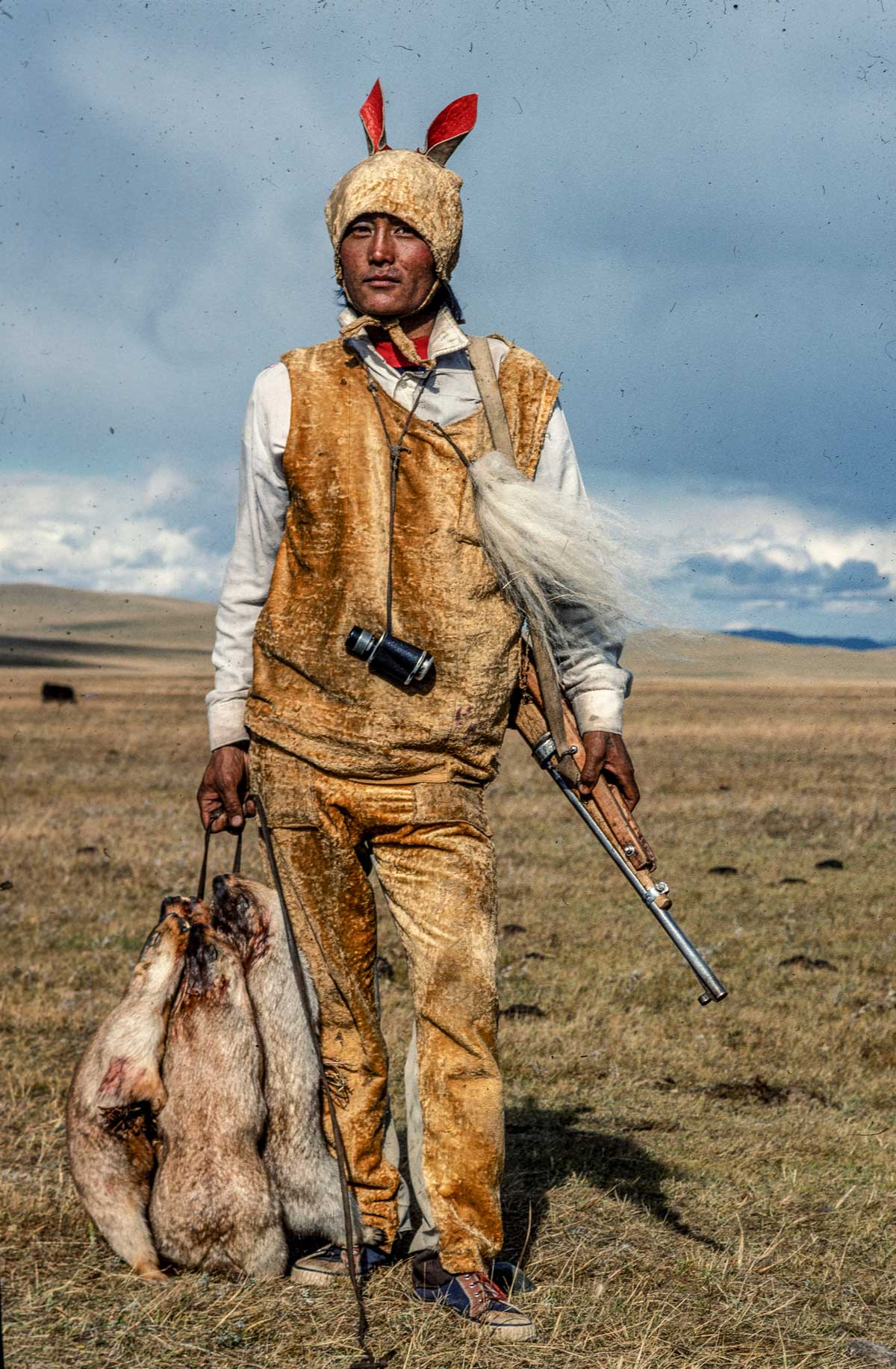 A Mongol marmot hunter disguised as his prey, Mongolia, 1990.