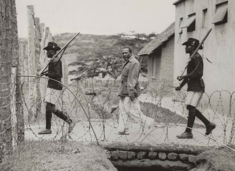 Jomo Kenyatta under guard at Kapenguria, 1952. Nationaal Archief. Public Domain.