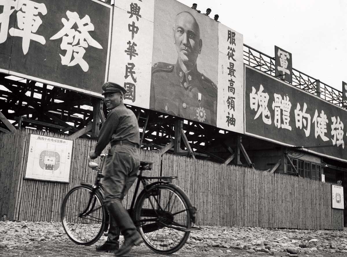 A soldier beneath a photo of Chiang Kai-shek inside the army gymnasium, Taipei, 1950s © Fernand Gigon/Getty Images.