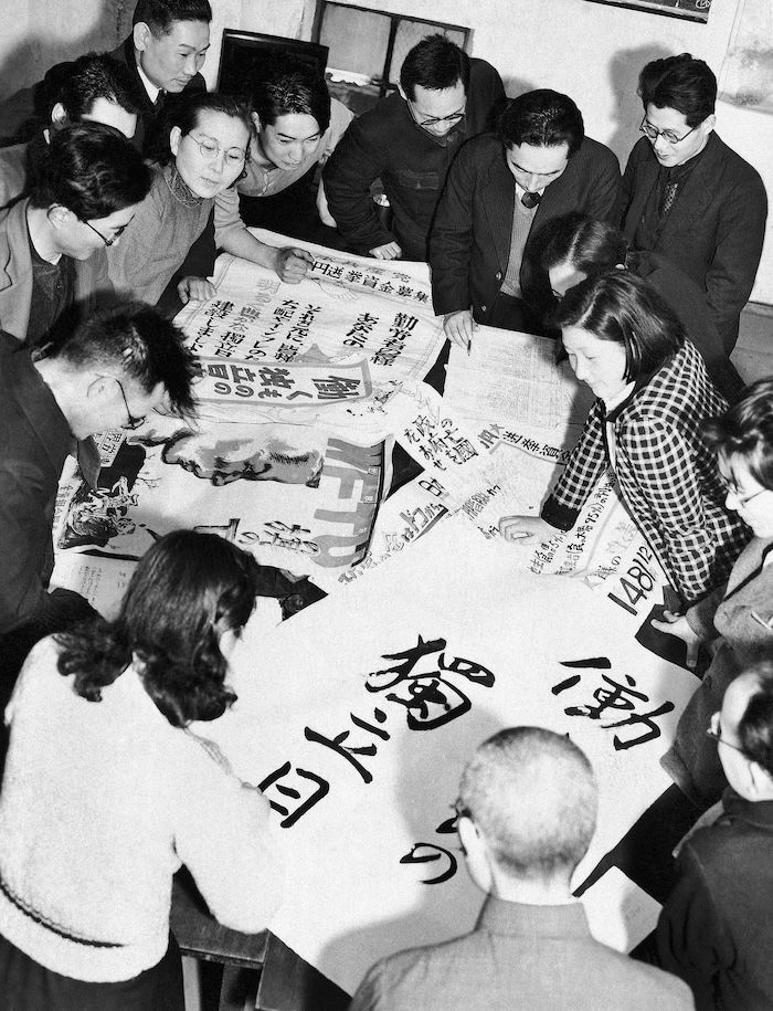 ‘The election day is the independence day for the workers.’ Communist Party members discussing slogans for an upcoming election, April 1947. Associated Press/Alamy Stock Photo.