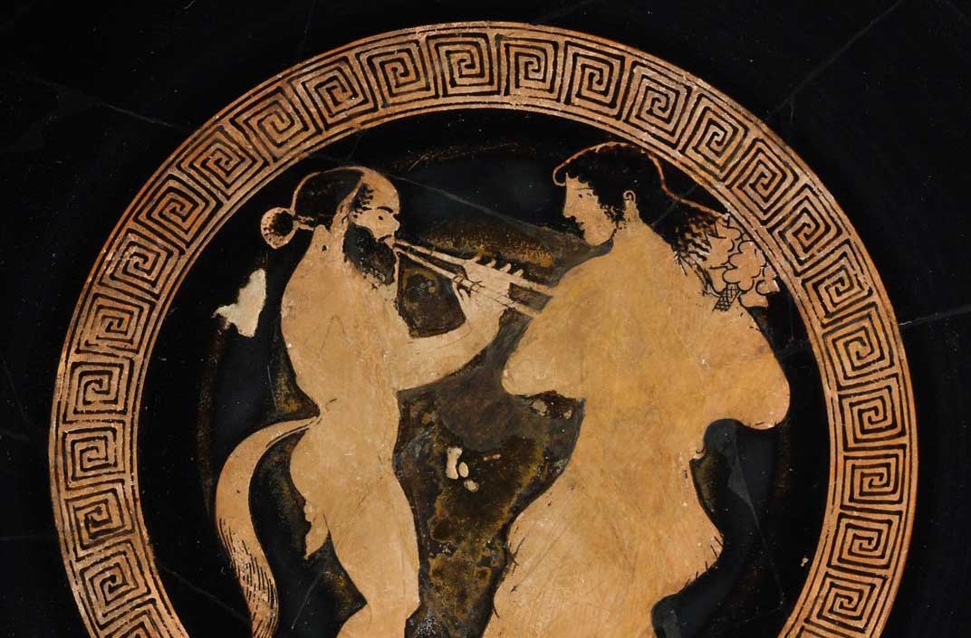 Terracotta kylix (drinking cup) ca. 480 B.C. Flute-playing satyr and maenad (detail), Signed by Hieron. Metropolitan Museum of Art.