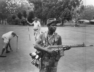 An armed guard provides security for white Rhodesian golfers at the Leopard Rock Hotel, Manicaland, 1978. Eddie Adams / Press Association Images
