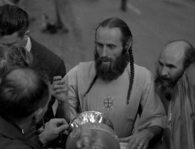 Bishop Asaiah talks with police and reporters outside the ruins of the headquarters of the Fountain of the World cult following an bomb attack by two former members, 11 December 1958. The Regents of the University of California (CC BY 4.0