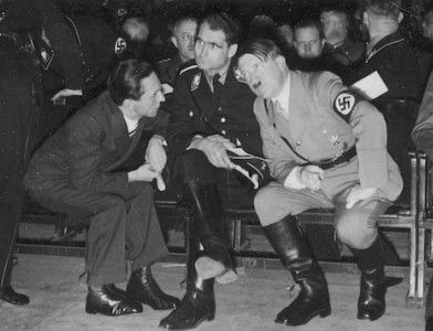 Adolf Hitler in conversation with minister of propaganda Joseph Goebbels and deputy fuhrer Rudolf Hess, December 1933. Potemkowska Aleksandra. Public Domain.