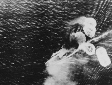 A photograph from a Japanese plane showing damage to HMS Repulse (bottom left) and HMS Prince of Wales (top right), 10 December 1941. US Naval History and Heritage Command. Public Domain.