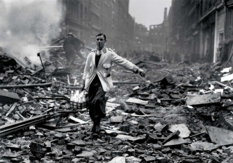 Staged photograph of a ‘milkman’ in a street devastated by a German bombing raid, Holborn, London, 10 September 1940.
