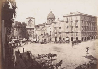 View of a square with the Porta Capuana in the background and the dome of the Santa Caterina a Formiello in Naples, Italy