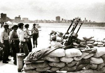 Cuban soldiers stand by an anti-aircraft gun, Havana, 1962.