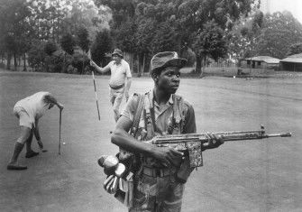 An armed guard provides security for white Rhodesian golfers at the Leopard Rock Hotel, Manicaland, 1978. Eddie Adams / Press Association Images