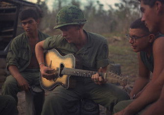US soldiers gather around a guitar player during Operation Yellowstone, 18 January 1968. NARA. Public Domain.